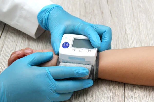 Doktor, böbrek hastalığı, tiroid, tümör, uyuşturucu, aşırı kilo, stres, şeker hastalığı ve sigara yüzünden hipertansiyon teşhisi koymak için hastayla birlikte tansiyon monitörü kullanır.