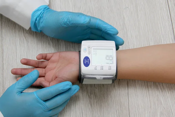 Doktor, böbrek hastalığı, tiroid, tümör, uyuşturucu, aşırı kilo, stres, şeker hastalığı ve sigara yüzünden hipertansiyon teşhisi koymak için hastayla birlikte tansiyon monitörü kullanır.