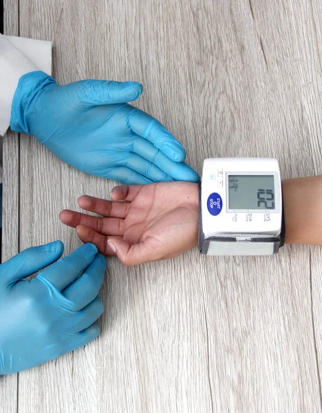 Doktor, böbrek hastalığı, tiroid, tümör, uyuşturucu, aşırı kilo, stres, şeker hastalığı ve sigara yüzünden hipertansiyon teşhisi koymak için hastayla birlikte tansiyon monitörü kullanır.