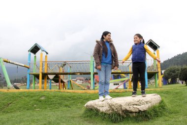 Latin kökenli anne ve kızı piknikte oynayıp eğleniyorlar. Uçurtma uçuruyorlar, ATV sürüyorlar, dans ediyorlar ve mutluluktan zıplıyorlar.