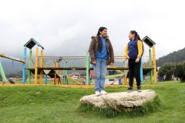 Latin kökenli anne ve kızı piknikte oynayıp eğleniyorlar. Uçurtma uçuruyorlar, ATV sürüyorlar, dans ediyorlar ve mutluluktan zıplıyorlar.