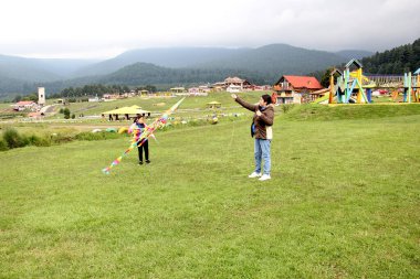 Latin kökenli anne ve kızı piknikte oynayıp eğleniyorlar. Uçurtma uçuruyorlar, ATV sürüyorlar, dans ediyorlar ve mutluluktan zıplıyorlar.