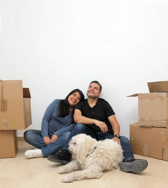 Couple of Latin man and woman move house thanks to a real estate agency they are happy for the beginning of a new life together and create a family