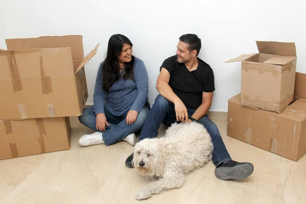 Couple of Latin man and woman move house thanks to a real estate agency they are happy for the beginning of a new life together and create a family