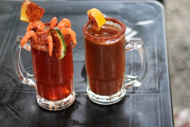 Micheladas açık hava masasında servis edilir. Bira, limon suyu, acı biber, tuz ve karides karışımı ile hazırlanmış bir Meksika alkollü içkisidir. 
