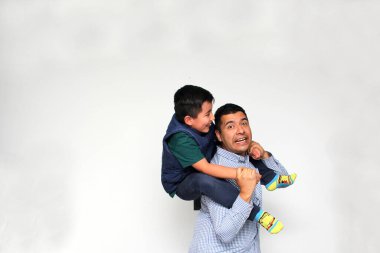 Koyu renk saçlı bekar baba Latin ve İspanyol oğul, Babalar Günü 'nde birlikte vakit geçirip zaferi kucaklayarak ve öpücüklerle kutlayarak eğleniyorlar.