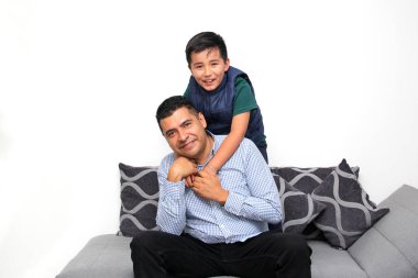 Koyu renk saçlı bekar baba Latin ve İspanyol oğul, Babalar Günü 'nde birlikte vakit geçirip zaferi kucaklayarak ve öpücüklerle kutlayarak eğleniyorlar.