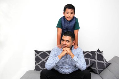 Koyu renk saçlı bekar baba Latin ve İspanyol oğul, Babalar Günü 'nde birlikte vakit geçirip zaferi kucaklayarak ve öpücüklerle kutlayarak eğleniyorlar.