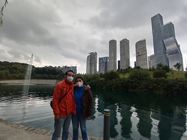 Young Latin couple of man and woman walk in the park sharing quality time playing frisbee and flying a kite outdoors doing sports and showing their love