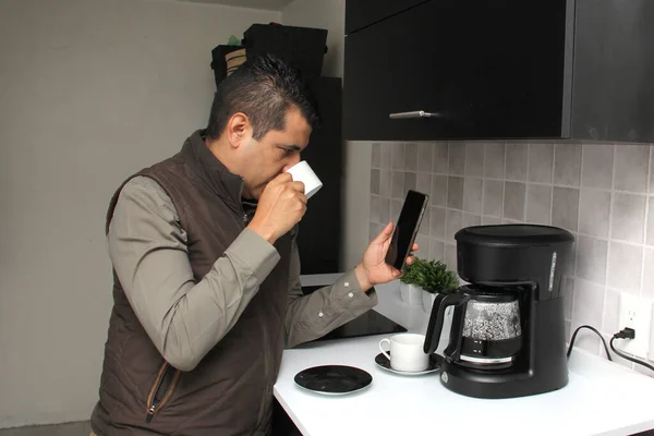 Hombre Adulto Latino Comienza Día Tomando Café Usando Celular Para —  Fotos de Stock