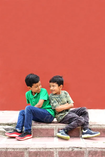 两个深色头发的拉丁裔男孩坐在公园的地上 生活贫困 没有玩具 没有梦想 没有玩耍 想象着一个快乐的童年 — 图库照片