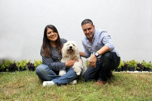Латиноамериканське Подружжя Постає Своїм Білим Пухнастим Собакою Різноманітна Сімейна Форма — стокове фото