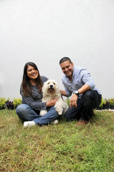 Латиноамериканське Подружжя Постає Своїм Білим Пухнастим Собакою Різноманітна Сімейна Форма — стокове фото