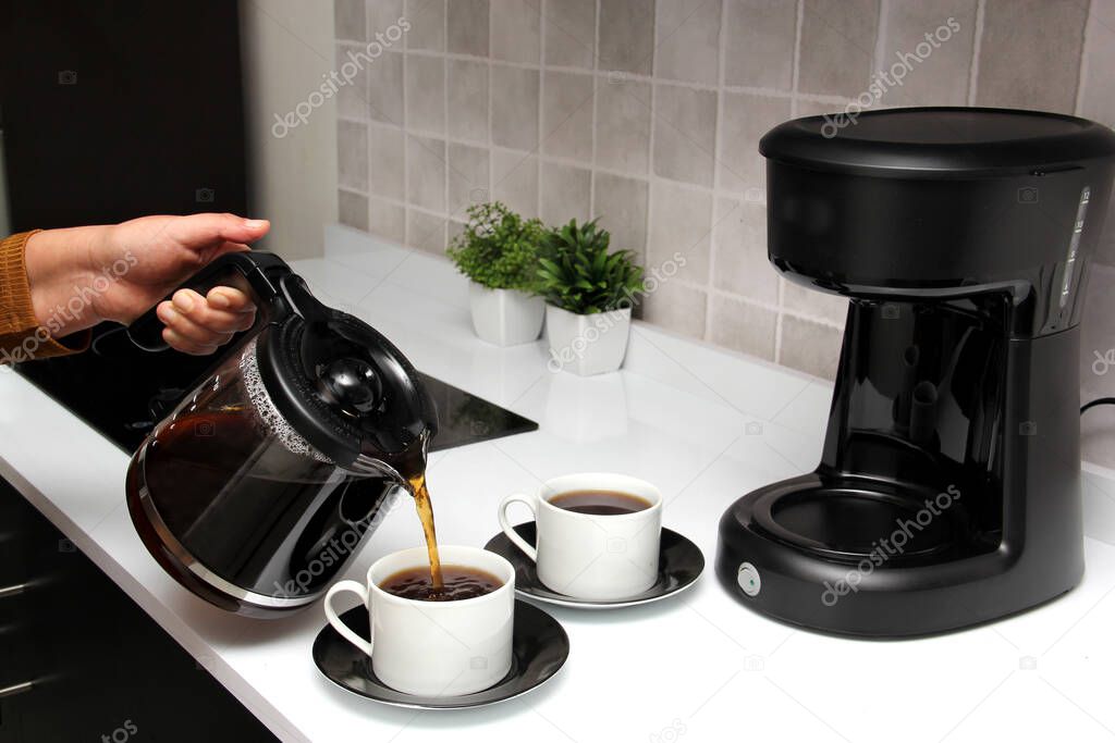 Woman's hands serve coffee prepared in a coffee maker to start the day with the benefits of antioxidants, protects against cancer, fights Alzheimer's and Parkinson's