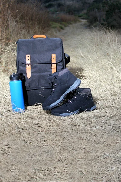 日出时在山上远足的背包 热水瓶和靴子 以及极端户外运动的设备 — 图库照片