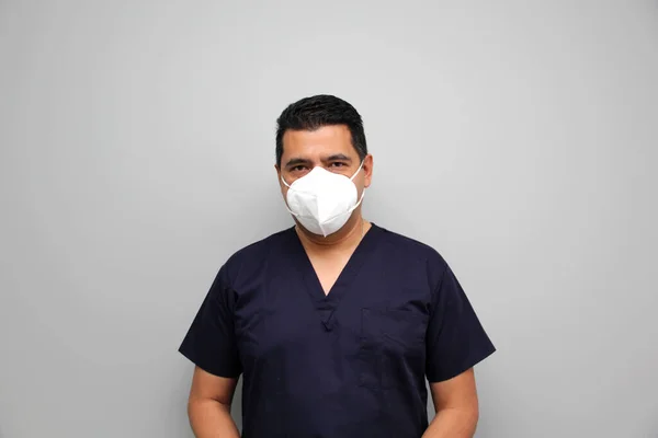 Latin male nurse with ubremouths and surgical uniform ready to see patients and enter the operating room at the hospital