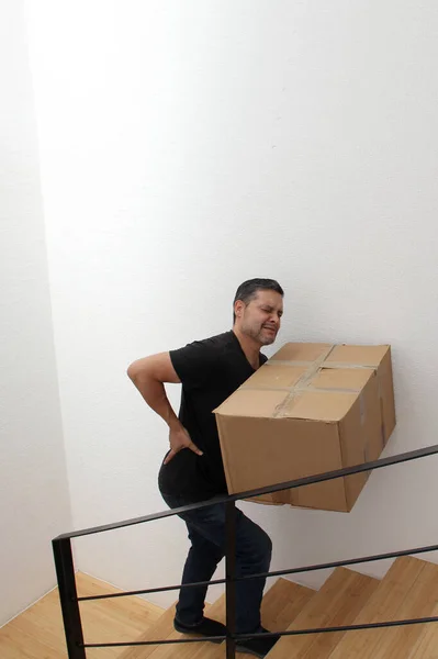 Λατίνος Ενήλικας Άντρας Κουβαλάει Ένα Βαρύ Χαρτονένιο Κουτί Στις Σκάλες — Φωτογραφία Αρχείου