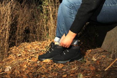 Siyah yürüyüş botlarıyla ormanda tehlikeli, maceraperest ve riskli bir gece yürüyüşü yapan birinin bacakları.