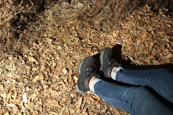 Legs of a person with black hiking boots doing dangerous, adventurous and risky night walk in the forest