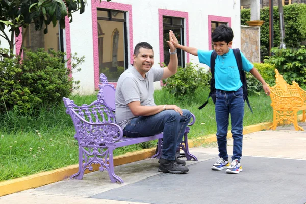 Latino Brown Dad Son Prepare Back School Backpack Sitting Park — Zdjęcie stockowe