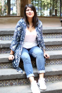 Latin adult woman sitting in a park enjoying the outdoors in relaxation and tranquility