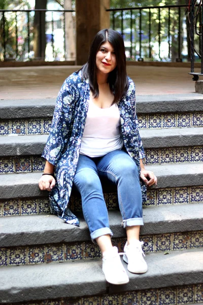 Latin adult woman sitting in a park enjoying the outdoors in relaxation and tranquility