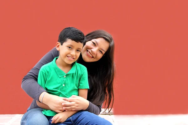Single mom and dark-haired Latino son play and have fun together spending quality family time on Mother's Day