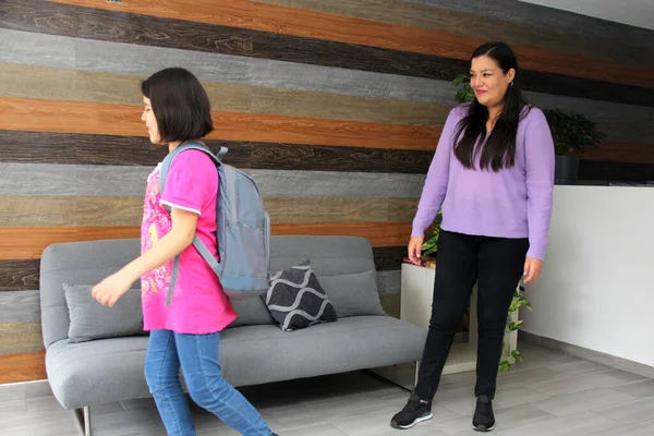 Latin mom with her 10 year old daughter prepare to go back to school with backpack vacations end