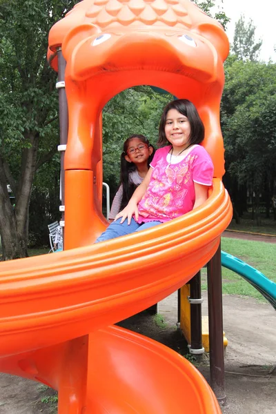 Latin sisters play in the outdoor park games together they spend quality time, take care of each other and exercise fun and happy