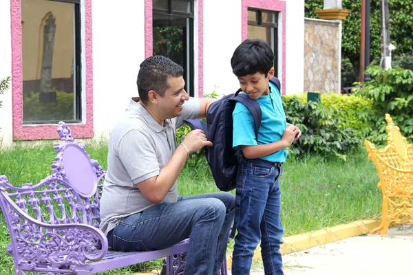 Latino Dad Checks His Son Backpack Return School Check Does — Zdjęcie stockowe