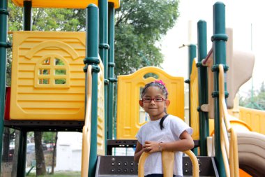 Little brunette latin woman girl with glasses plays outdoors in free games, happy, doing physical activity