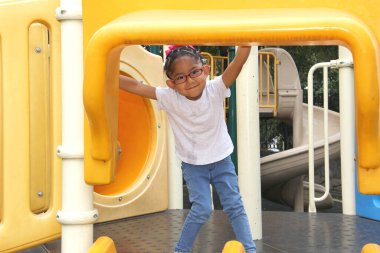Little brunette latin woman girl with glasses plays outdoors in free games, happy, doing physical activity