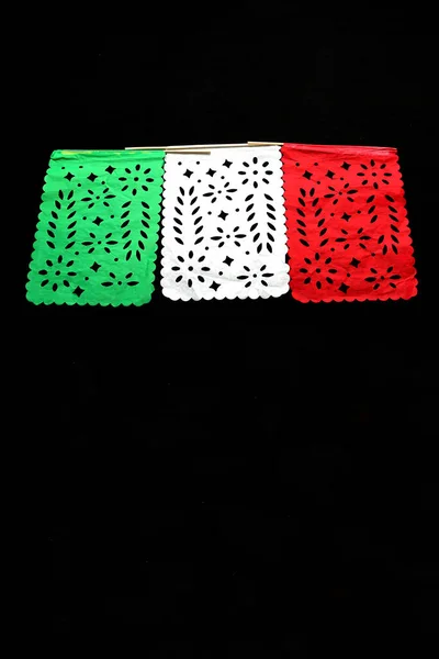 Mexican party pennants handmade with green, white and red cut-out paper like the flag of Mexico to celebrate the national holidays of independence