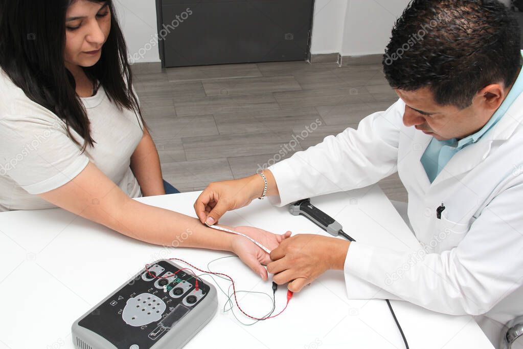 Latin doctor specialist neurologist performs a study of evoked potentials, diagnostic techniques with sensory stimuli and the recording of stimulated brain responses to a female patient.