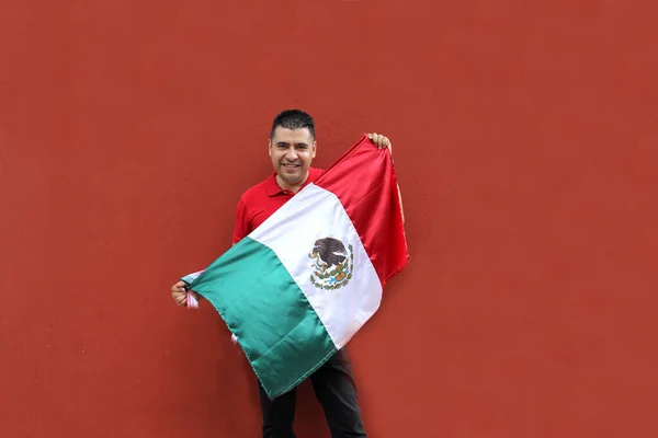 ラテン系メキシコ人の成人男性は 彼の文化と伝統を誇るメキシコの旗を示しています9月の15 シンコ マヨとサッカーの祝日を祝います — ストック写真
