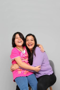 Latin kökenli anne ve kız oynuyor, dans ediyor, sürpriz yapıyor, eğleniyor, cep telefonu harcamak için ailece vakit geçiriyorlar.