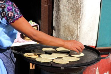 Yerli bir kadının Comal, geleneksel yemek üzerinde tortilla yapmasını izlemek