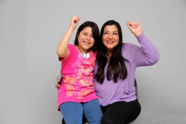 Latin kökenli anne ve kız oynuyor, dans ediyor, sürpriz yapıyor, eğleniyor, cep telefonu harcamak için ailece vakit geçiriyorlar.