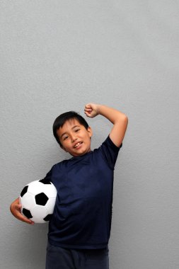 Latin kökenli 8 yaşındaki çocuk futbol topuyla oynuyor. Dünya Kupası 'nı izleyeceği için çok heyecanlı ve takımının kazandığını görmek istiyor.