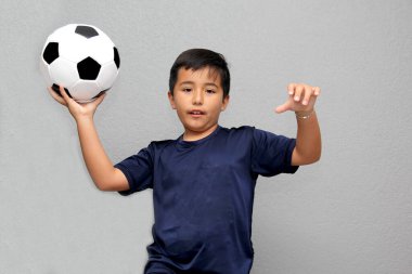 Latin kökenli 8 yaşındaki çocuk futbol topuyla oynuyor. Dünya Kupası 'nı izleyeceği için çok heyecanlı ve takımının kazandığını görmek istiyor.