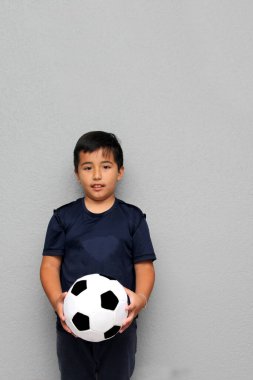 Latin kökenli 8 yaşındaki çocuk futbol topuyla oynuyor. Dünya Kupası 'nı izleyeceği için çok heyecanlı ve takımının kazandığını görmek istiyor.