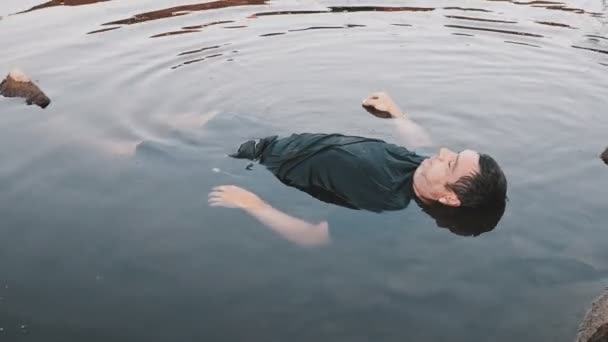 一个人淹死了 死在水里 一个年事已高的年轻人的尸体躺在湖里 一个尸体躺在一个肮脏的池塘里不稳定的相机的颜色校正 — 图库视频影像