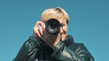 Kameralı bir paparazzi kız yakın çekim yaparken caddenin fotoğraflarını çekiyor.
