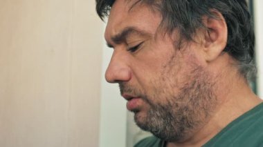 Yakından sigara içen yetişkin bir adamın yüzü..