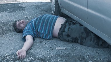 Bir araba kazasından sonra yolda ölü bir adam yatıyor..