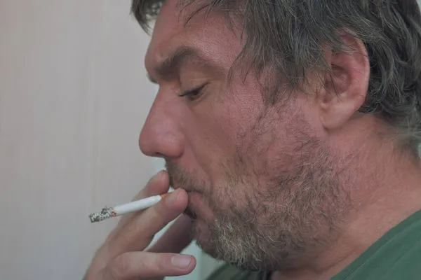 Бездомный Старым Лицом Курит Сигарету Смотрит Пол — стоковое фото
