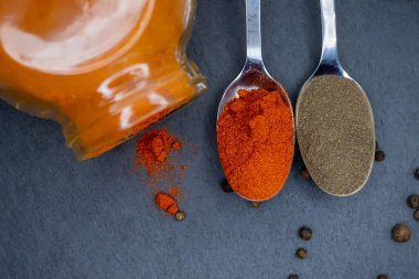 Kırmızı biberli kavanoz ve kaşık, ve koyu arkaplanda bezelye, üst manzara. Yakın plan..