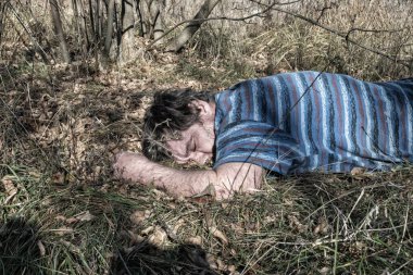 Yetişkin, evsiz bir adamın cesedi çimlerin arasındaki ormanda bulundu..