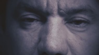 Yaşlı bir insanın yüzüne yakın çekim yap. Güzel, yaşlı gözlerini açıyor. Beyaz erkek model, yeşil, gri gözlü, kameraya bakıyor. Yavaş çekim, makro, aşırı yakın çekim, seçici odaklanma