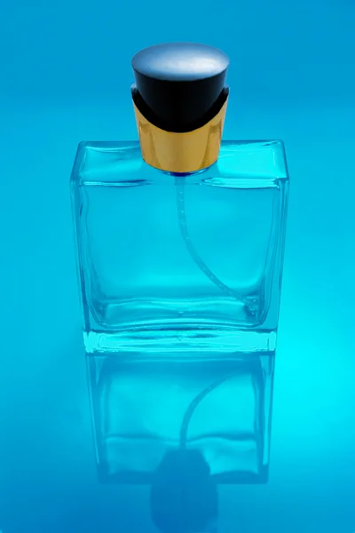 Transparent Perfume bottle isolated with reflection in blue tint — Stock Photo, Image